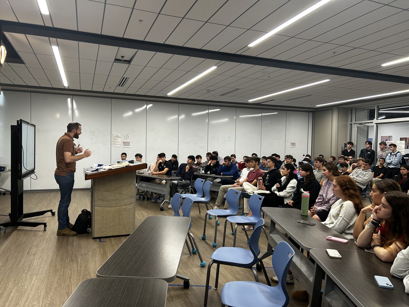 Yitzi Stern speaking to a packed audience